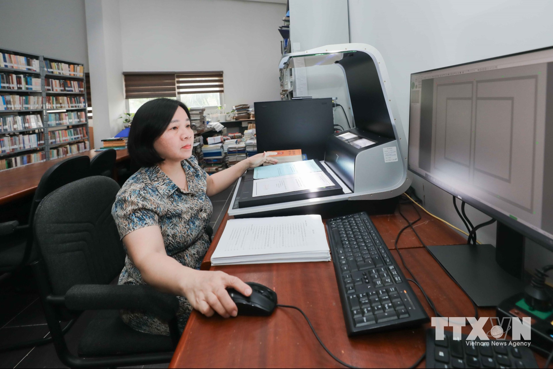 Nhân viên Bảo tàng thực hiện scan hình ảnh hiện vật, tài liệu phục vụ số hóa, xây dựng cơ sở dữ liệu, lưu trữ thông tin khoa học, góp phần bảo tồn, quản lý và phát huy giá trị di sản văn hóa. (Ảnh: Phan Phương/TTXVN)
